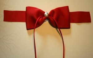 Schicke rote Schleife mit einer halben Perle dekoriert, Geschenkschleife liebevoll dekoriert, Fertigschleife