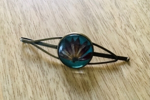 Haarschmuck -  Echte Sterndoldenblüte unter einem Glascabochon in einer Haarklammer