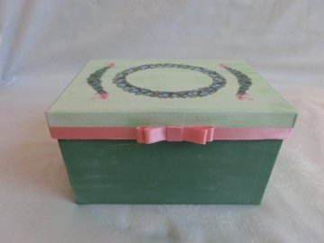 Rechteckige grüne Schachtel mit Satinband und Poesiebildern verziert, 9,50cm hoch 11cm breit und mit Deckel 16cm lang