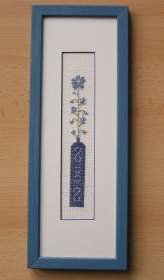 Gestickte schlanke Blumenvase im blauen Rahmen