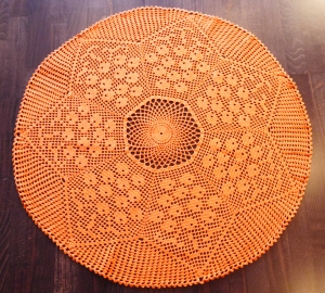 runde orangefarbene Filethäkel-Tischdecke mit Blumenmuster
